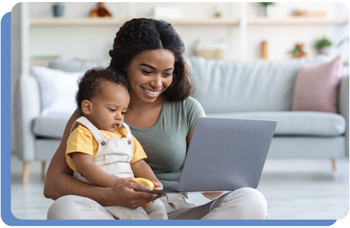 Mother happy and relief looking at a computer screen while holding a baby on her lap