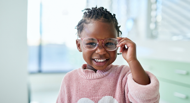 Young girl adjusting her eye glasses.