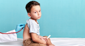 Doctor is examining young boy